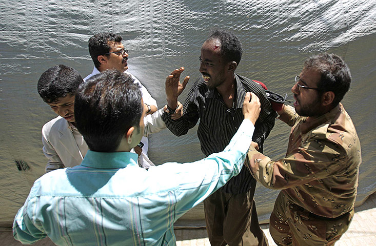 Yemen violence resumes: A defected army soldier and passers-by comfort a Somali man