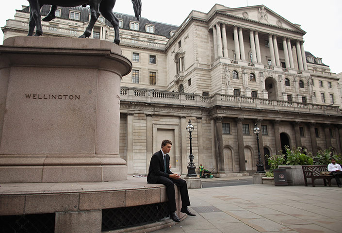 Week in Business: A city worker sits alone in front of the Bank of England 
