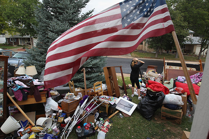 Week in Business: A woman stands among her family's possessions after they were evicted