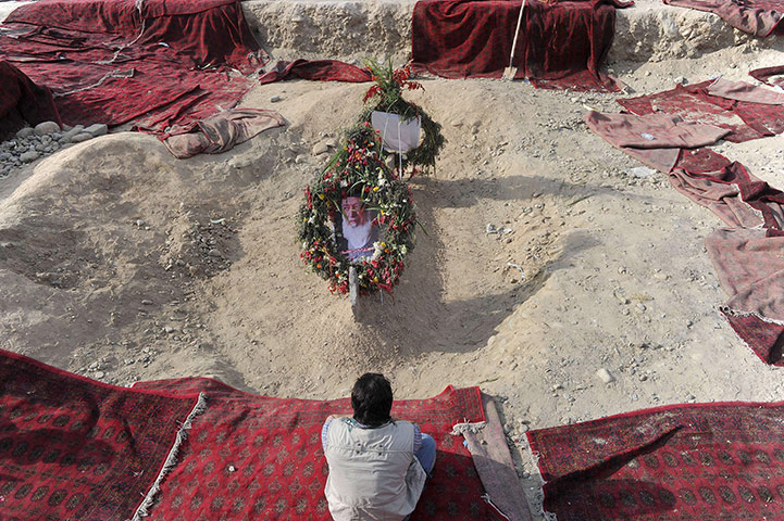 Rabbani funeral: A mourner prays at Rabbani's graveside