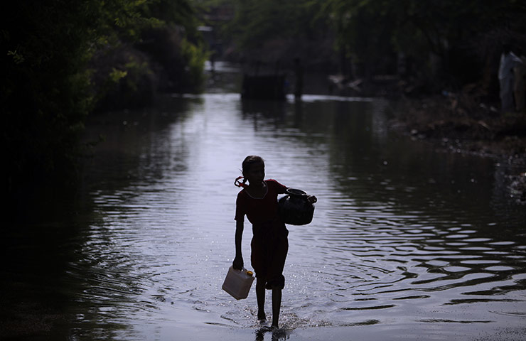 24 Hours: A displaced girl crosses a flooded field after fleeing her flood-hit home