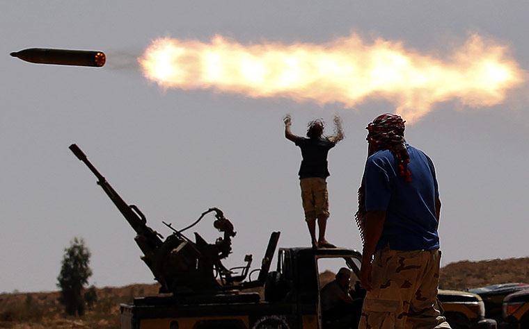 24 Hours: An anti-Gaddafi fighter walk in a village outside Sirte