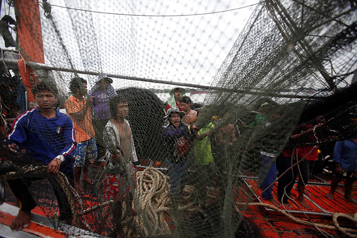 24 hours in pictures: Mahachai, Thailand: Migrant workers from Burma work on a fishing boat