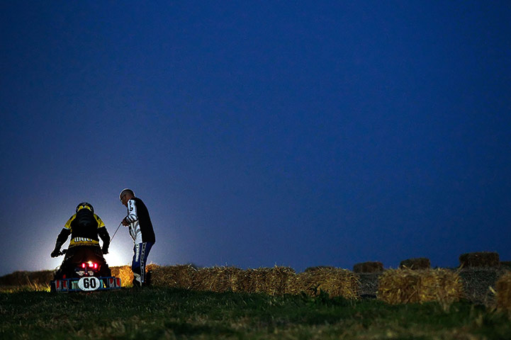 24 hours in pictures: Billingshurst, England: A competitor's mower is restarted  by the track