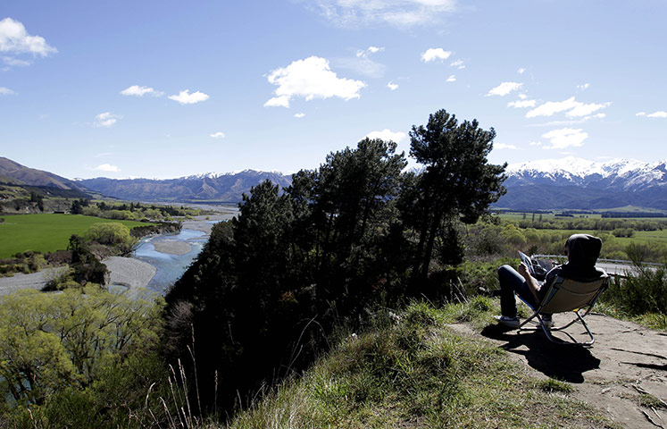 24 hours: Hanmer Springs, New Zealand: A tourist reads a newspaper 