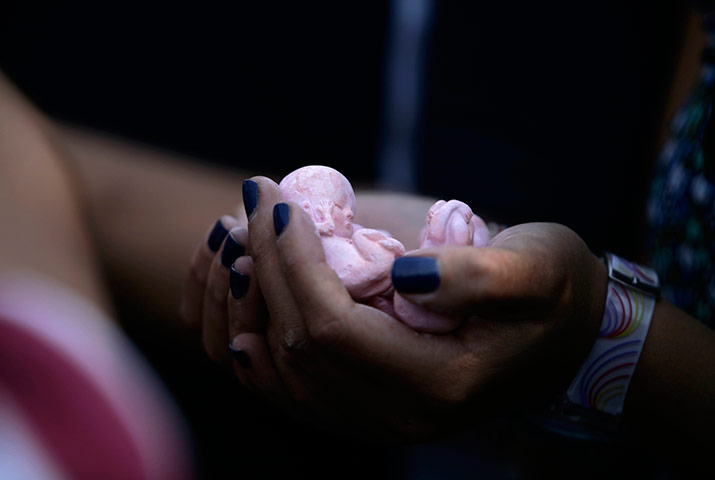 24 horus in pictures: An anti-abortion activist holds clay dolls, Mexico