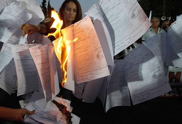 24 horus in pictures: Protesters from the Greek Communist-affiliated trade union PAME burn bills