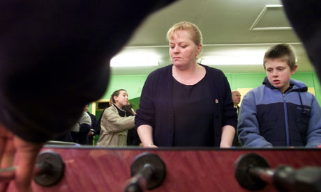 Volunteer youth worker playing table football.