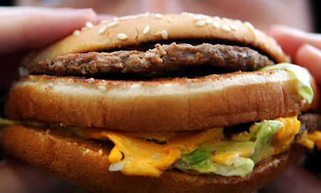 Woman eats a beefburger.
