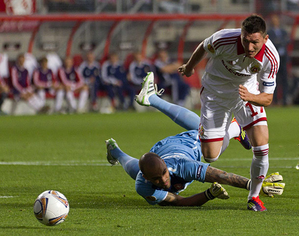 Europa League: Wisla Krakow's Andraz Kirm skips over FC Twente goalkeeper Nikolay Mihaylov