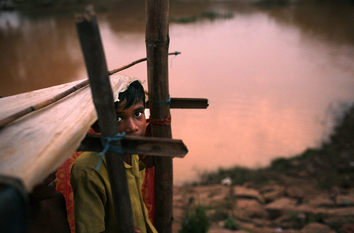 24 hours in pictures: Patamundi, India: A young villager stands in a makeshift shelter