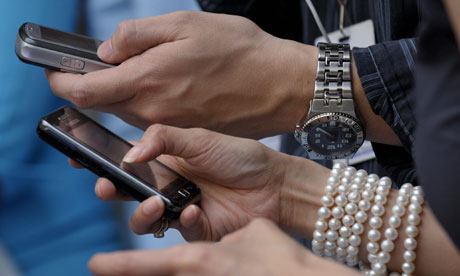 Shoppers at a mall send text messages