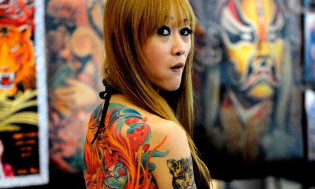 A woman displays her tattoo