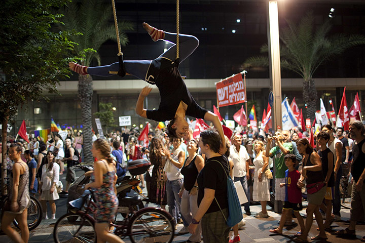 Protests in Israel: An acrobat performs during a protest in the centre of Tel Aviv 