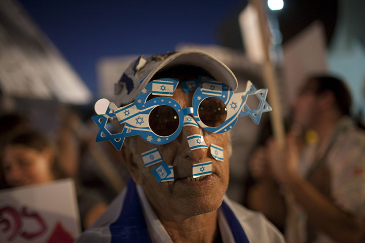 Protests in Israel: A protester with stickers of the Israeli flag on his face demonstrates