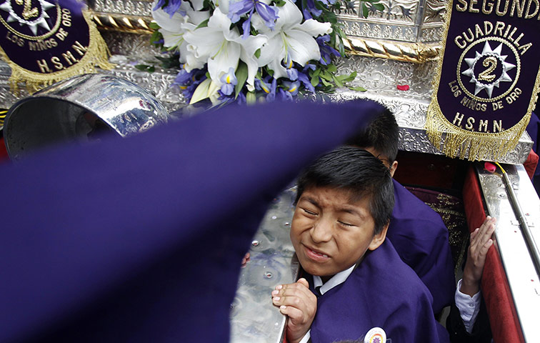 24 hours: Lima, Peru: Children carry a replica of the Lord of the Miracles