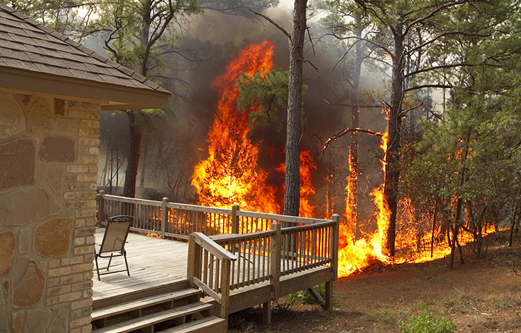 Texas Wildfires: A fire creeps toward a house on Mauna Kea Lane in Bastrop, Texas