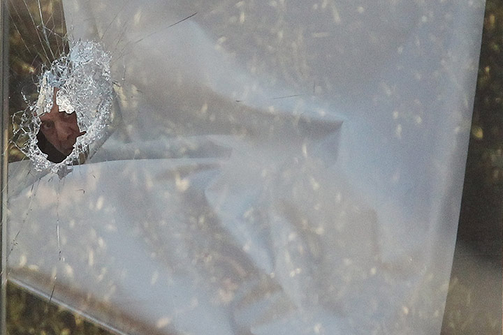 24 hours in pictures: A man looks through a broken window during a  seige in Parramatta 