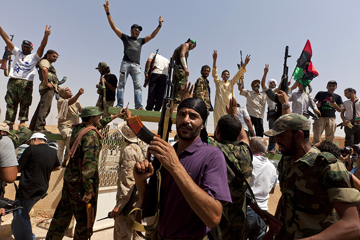 Sean Smith: Bani Walid: Libyan NTC fighetrs fire their weapons in the air and chant at a checkpoint