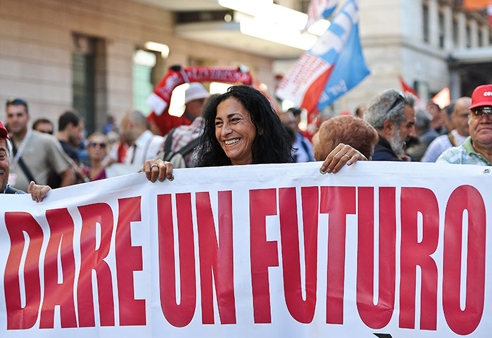 Italy strike: Workers hold a banner as they march during a demonstration in Rome