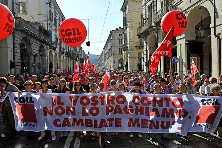 Italy strike: People hold a banner as they march through downtown Turin