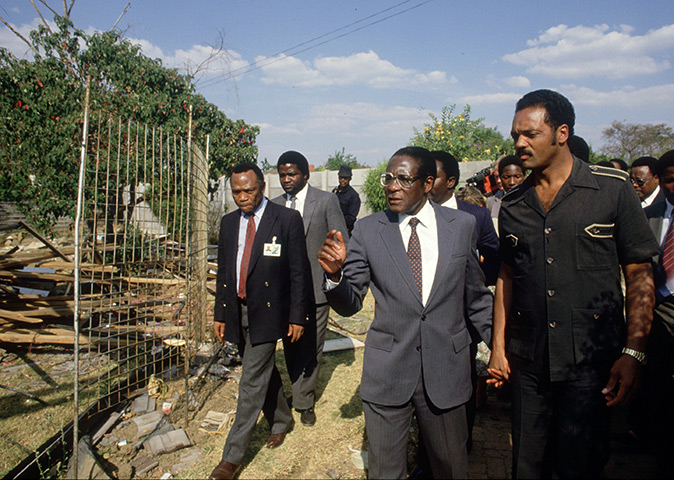 Robert Mugabe: 1986: Zimbabwe PM Robert Mugabe walks hand in hand with Jesse Jackson 