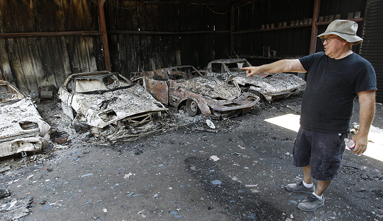 Wildfires damage: Car collector John Chapman surveys the losses at his home 