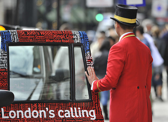 Week in Business: A doorman closes a taxi door outside a hotel in central London