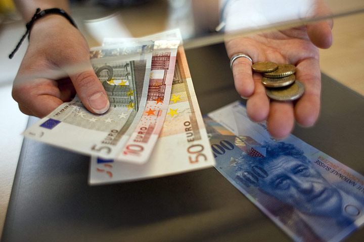 Week in Business: A woman changing Swiss francs to Euros at a counter in Switzerland
