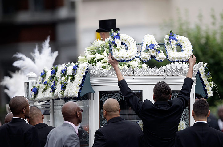 Funeral of Mark Duggan: A man removes a floral tribute