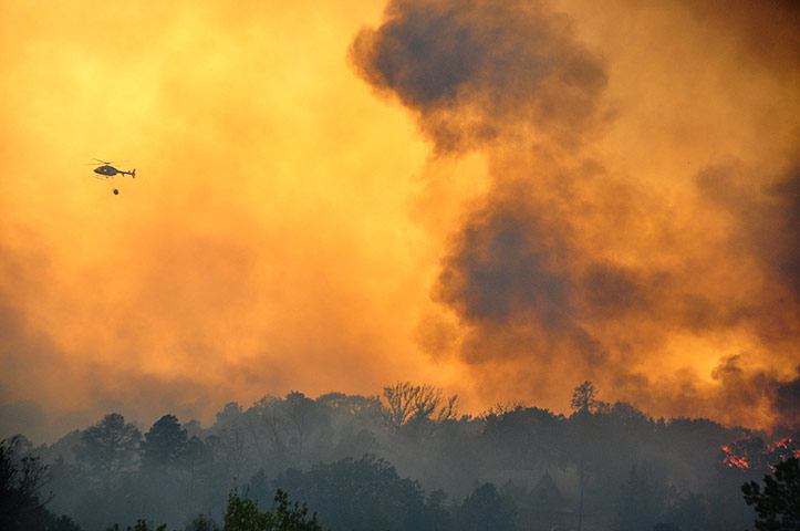 24 hours in pictures: Jefferson, US: A helicopter carries in water to be dropped on a wildfire