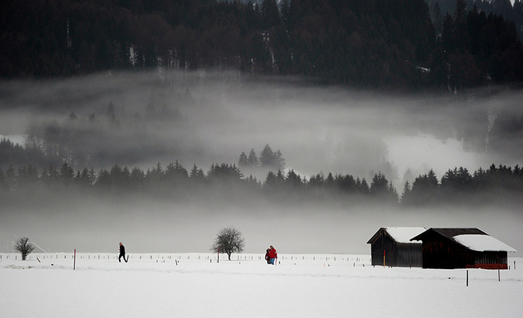 24 hours: Oberstdorf, Germany: Strollers walk through the fog 