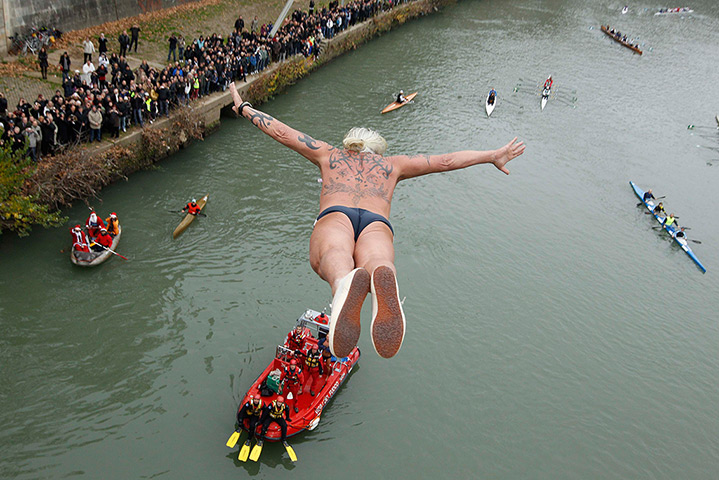New Years day swimmers: Maurizio Palmulli of Italy dives into the Tiber river, Rome