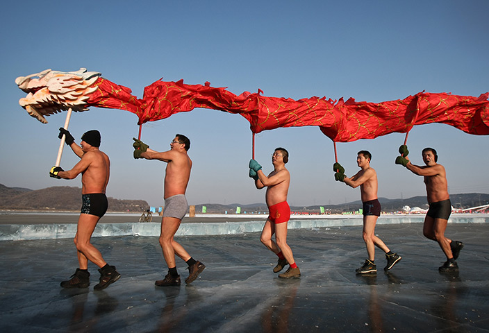 New Years day swimmers: Chinese winter swimmers perform a dragon dance on a frozen lake, Shenyang