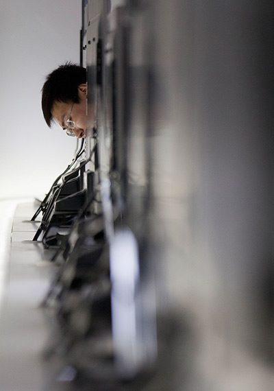 24 hours in pictures: Buyer examines the back components od 3D TVs at Consumer Electronics Show 