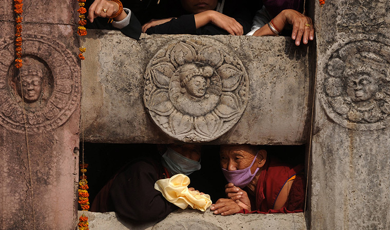 24 hours in pictures: Buddhist devotees wait for the arrival of the Dalai Lama