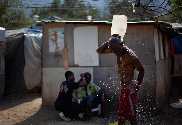 24 hours in pictures: A man bathes at the temporary camp of Champ de Mars, Haiti