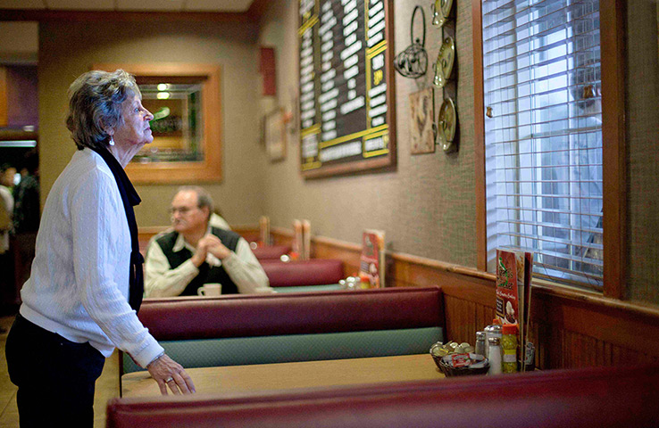 24 hours in pictures: Woman looks out window to Republican presidential candidate Rick Perry