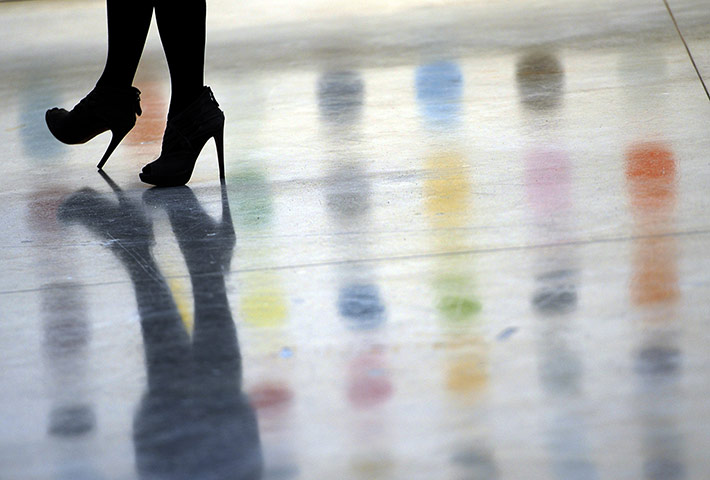 Hirst at Gagosian Gallery: A woman walks past  the reflection of a painting