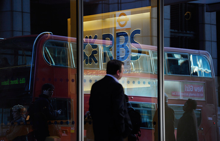 Week in business: Pedestrians are reflected as they walk by the Royal Bank of Scotland