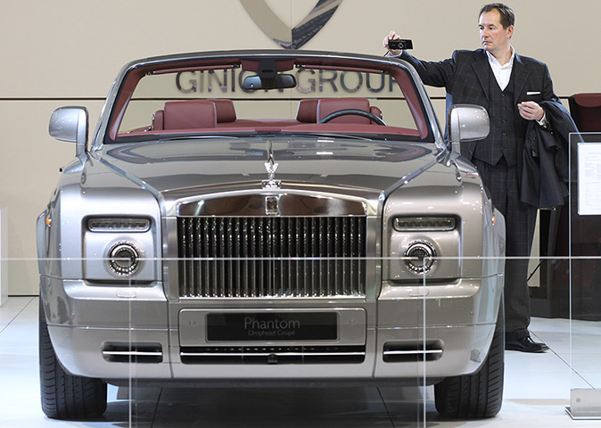 Week in business: A man takes a photo of a Phantom Rolls Royce at the Brussels Motor Show