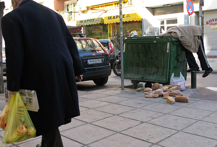 Week in business: A man collects bread from a  bin in the city of Thessaloniki, Greece