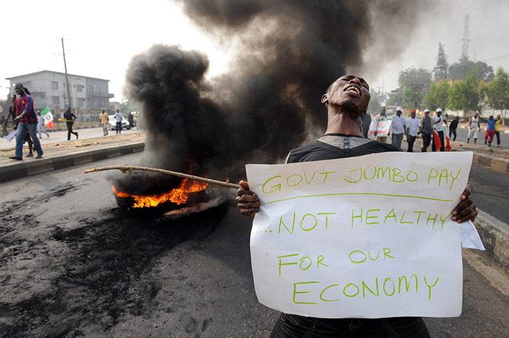 Week in business: A man carries a placard during a demo in Lagos