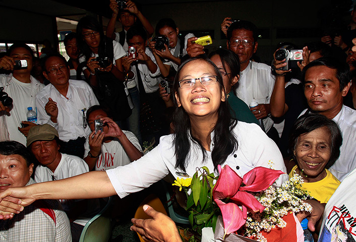 Burma prisoner released: Nilar Thein shakes hands as she arrives at Rangoon airport