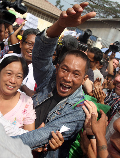 Burma prisoner released: Prisoner waves as he comes out of the Insein prison in Rangoon