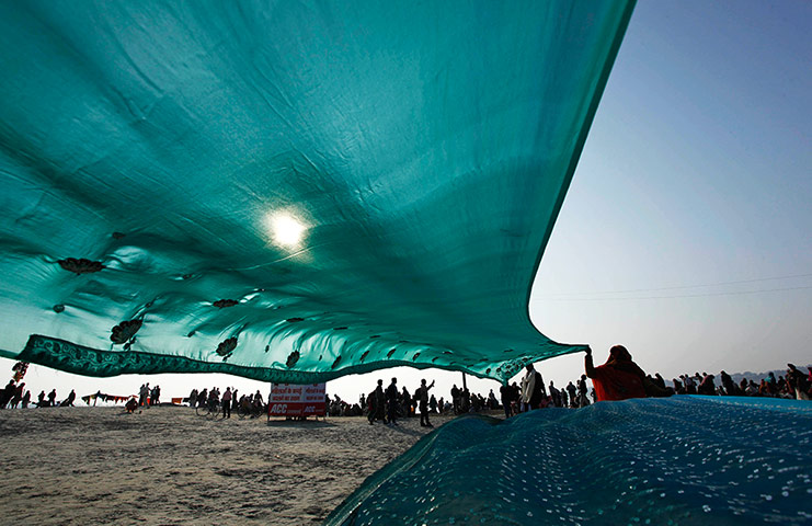 Ganges: Devotees hold their saris up to dry after taking a dip 