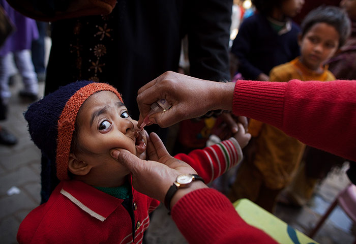 Polio vacination: A child is administered a polio drop at a health camp in Uttar Pradesh