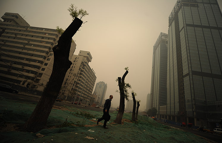 China environmental year: A man walks through heavy pollution on a street in Beijing