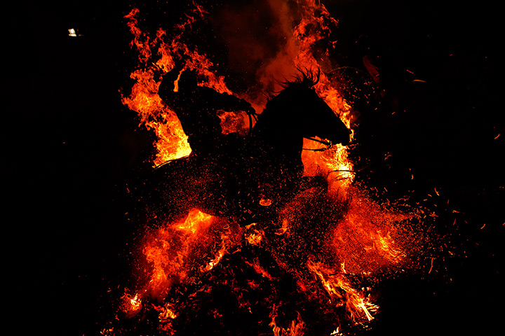 Luminarias, Spain: A rider and his horse are silhouetted by the fire