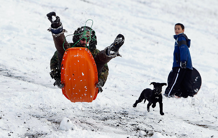 24 hours in pictures: Cottage Grove, US: A mansledges down a snowy slope
